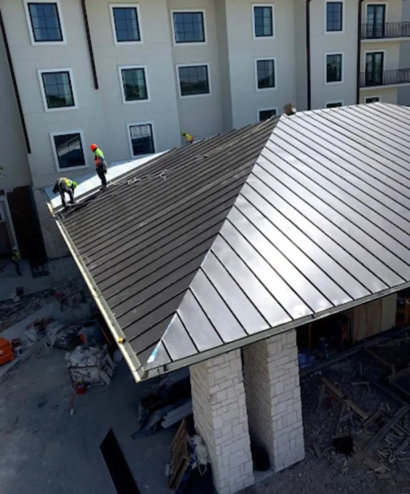 Crew installing standing seam metal roof panels on a commercial project in Panama City Beach